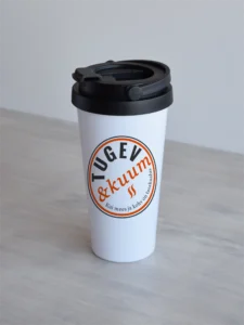 500-ml-termoskruus-tugev-ja-kuum-oranz Valge 500ml termoskruus, millel on ümmargune embleem kirjaga "Tugev & kuum", oranž-tumehall, minimalistlik disain.