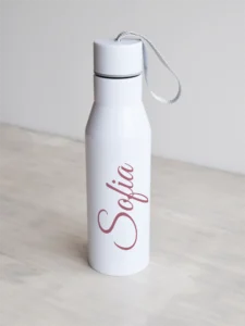 Nimelin valge joogipudel , elegantse script fondiga, roosa tekst.